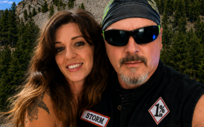 Norman Gregory Fernandez and Teri Fernandez posing in front of Mount Rushmore during a motorcycle road trip in South Dakota.